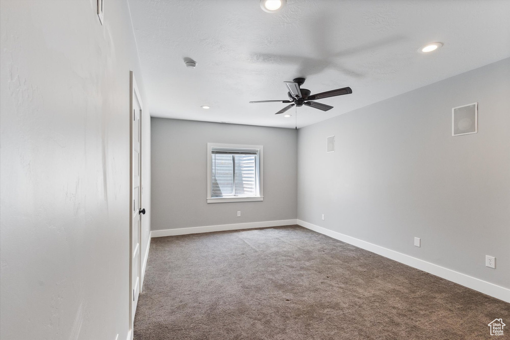 Carpeted empty room with ceiling fan and recessed lighting