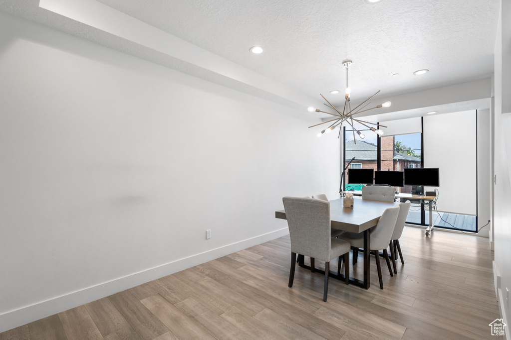 Dining room with a chandelier, light wood-style floors, recessed lighting, and a textured ceiling