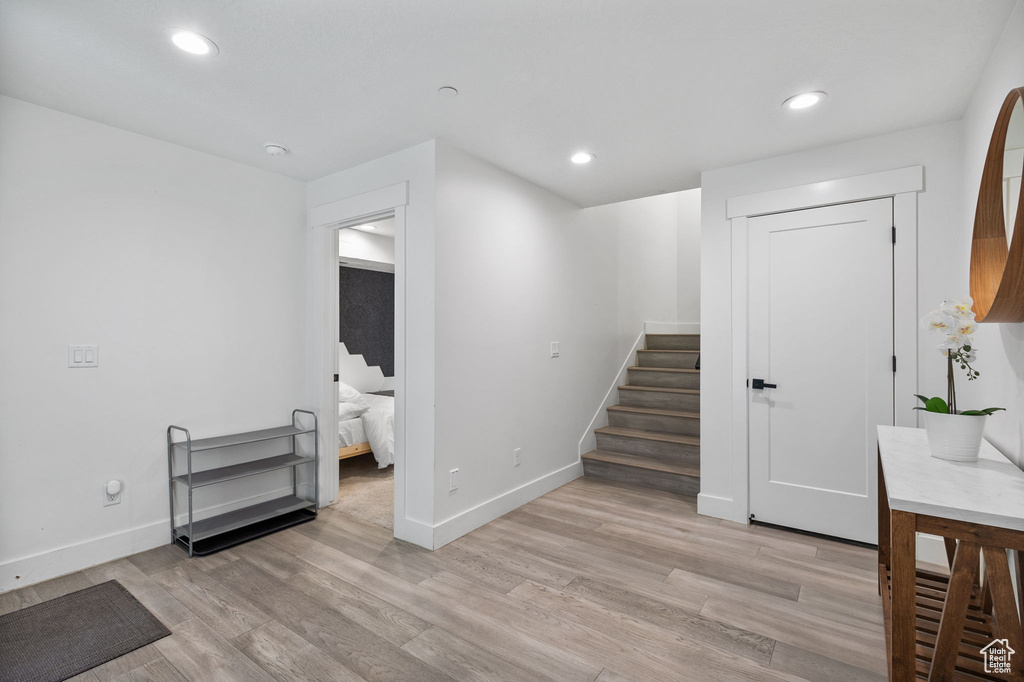 Stairway with wood finished floors and recessed lighting