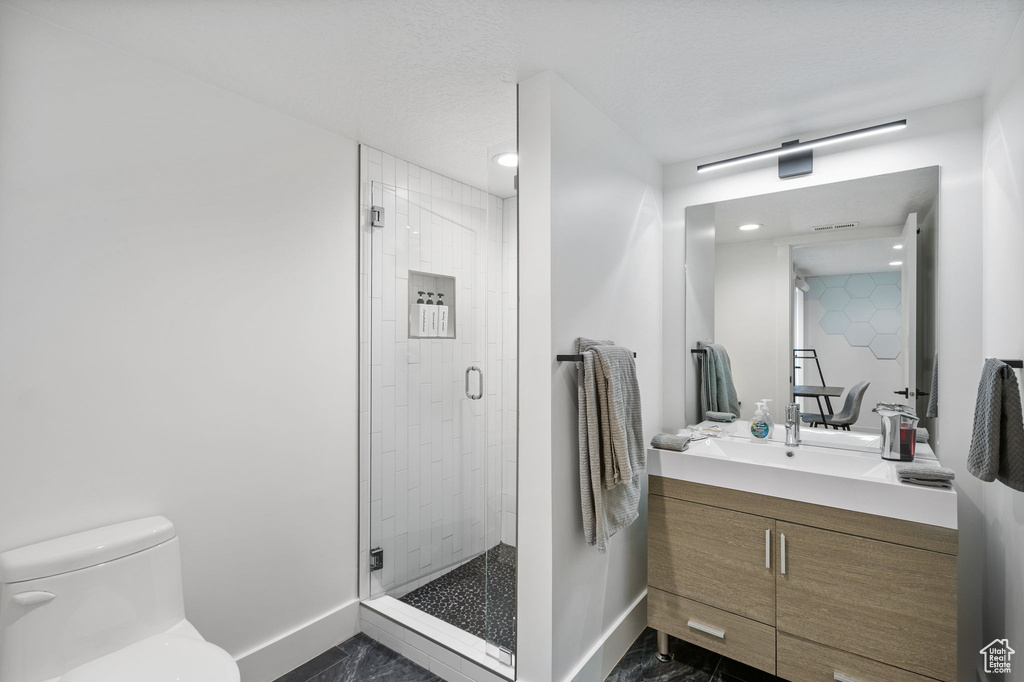 Full bathroom featuring vanity, a stall shower, marble finish floors, and recessed lighting