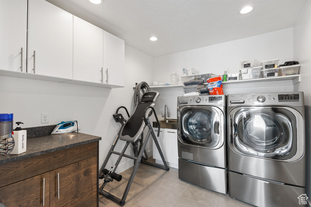 Washroom featuring separate washer and dryer, cabinet space, recessed lighting, and light tile patterned floors