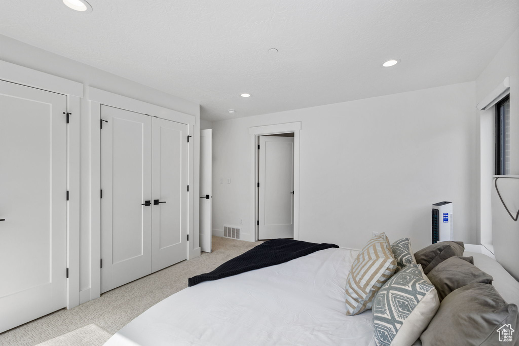 Bedroom featuring light carpet and recessed lighting