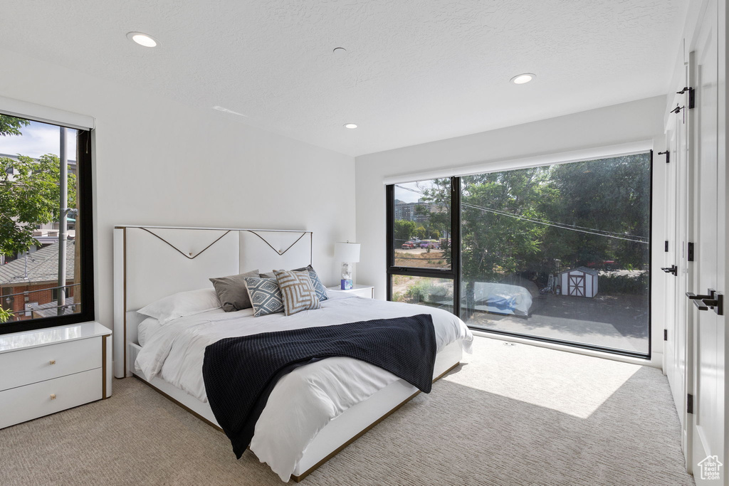 Carpeted bedroom featuring access to exterior, multiple windows, and recessed lighting