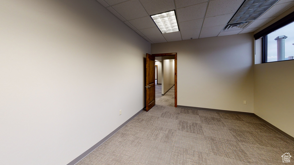 Spare room with light carpet and a drop ceiling