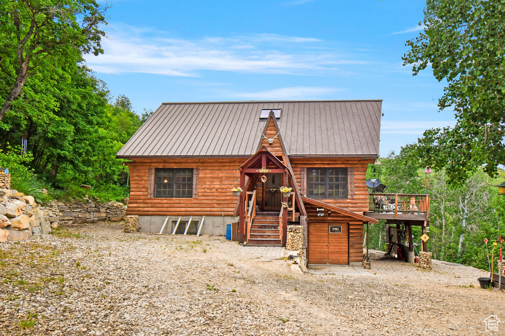 View of front of home featuring a metal roof and a deck