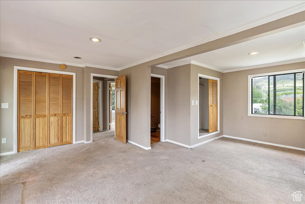 Unfurnished bedroom featuring ornamental molding, light carpet, recessed lighting, and a closet