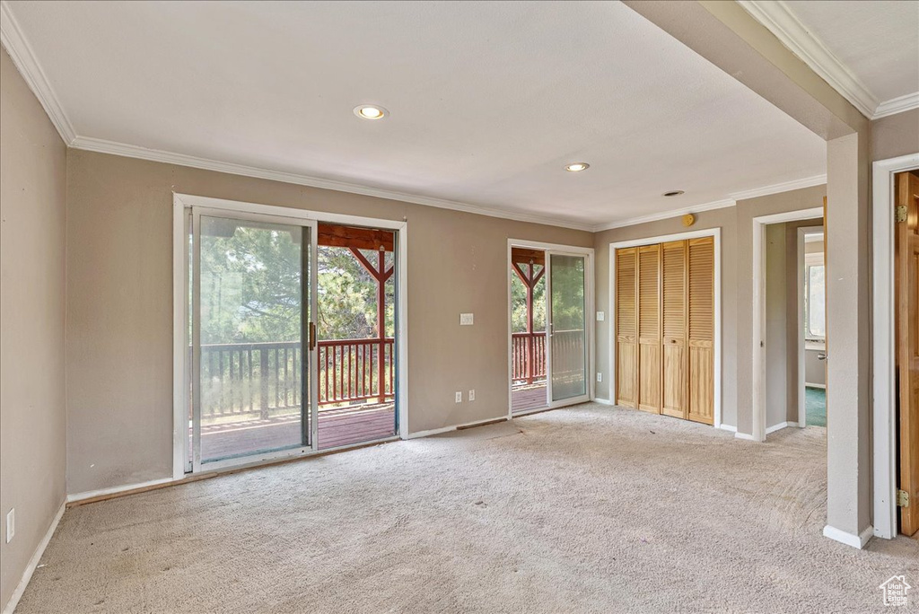Unfurnished bedroom with access to outside, light colored carpet, ornamental molding, and recessed lighting