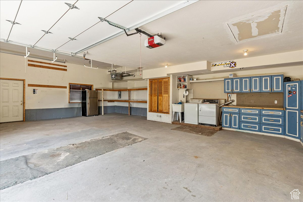 Garage featuring a garage door opener and washer and clothes dryer