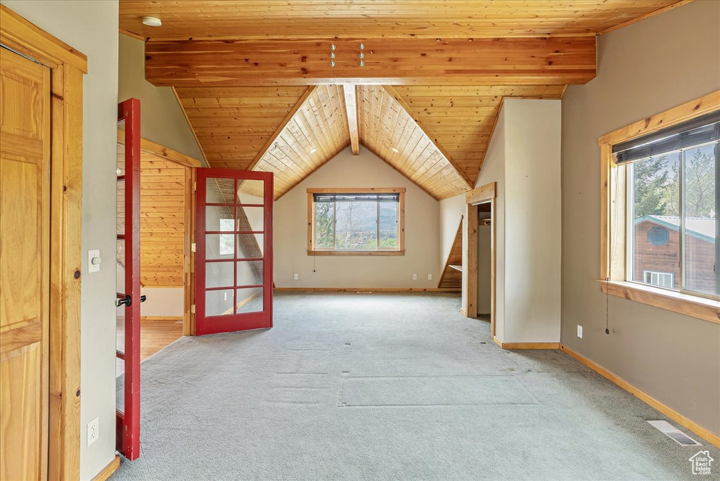 Unfurnished room featuring carpet floors, wood ceiling, lofted ceiling, and stairway