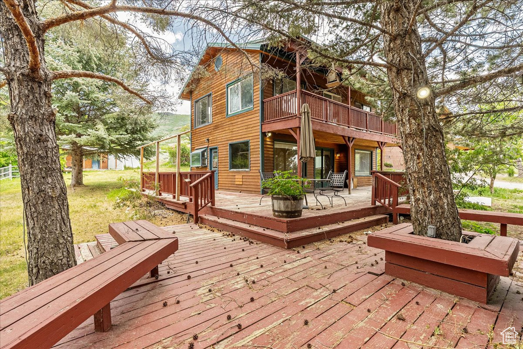Wooden terrace featuring a patio and a lawn