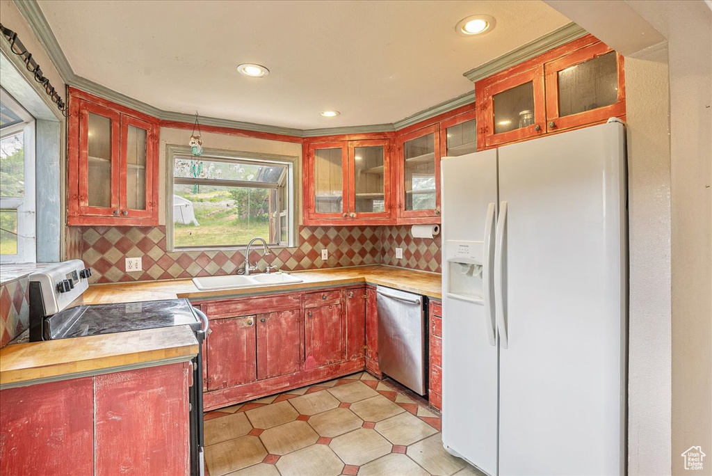 Kitchen with white fridge with ice dispenser, stainless steel dishwasher, electric range, tasteful backsplash, and recessed lighting