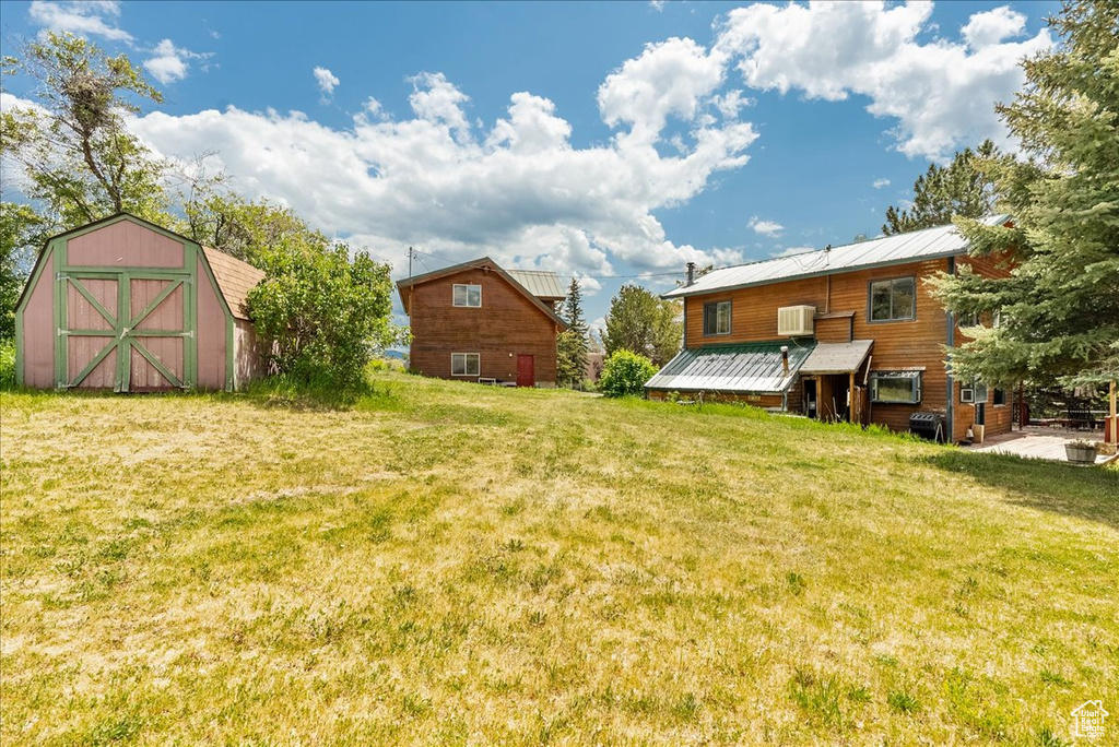 View of grassy yard with a storage shed