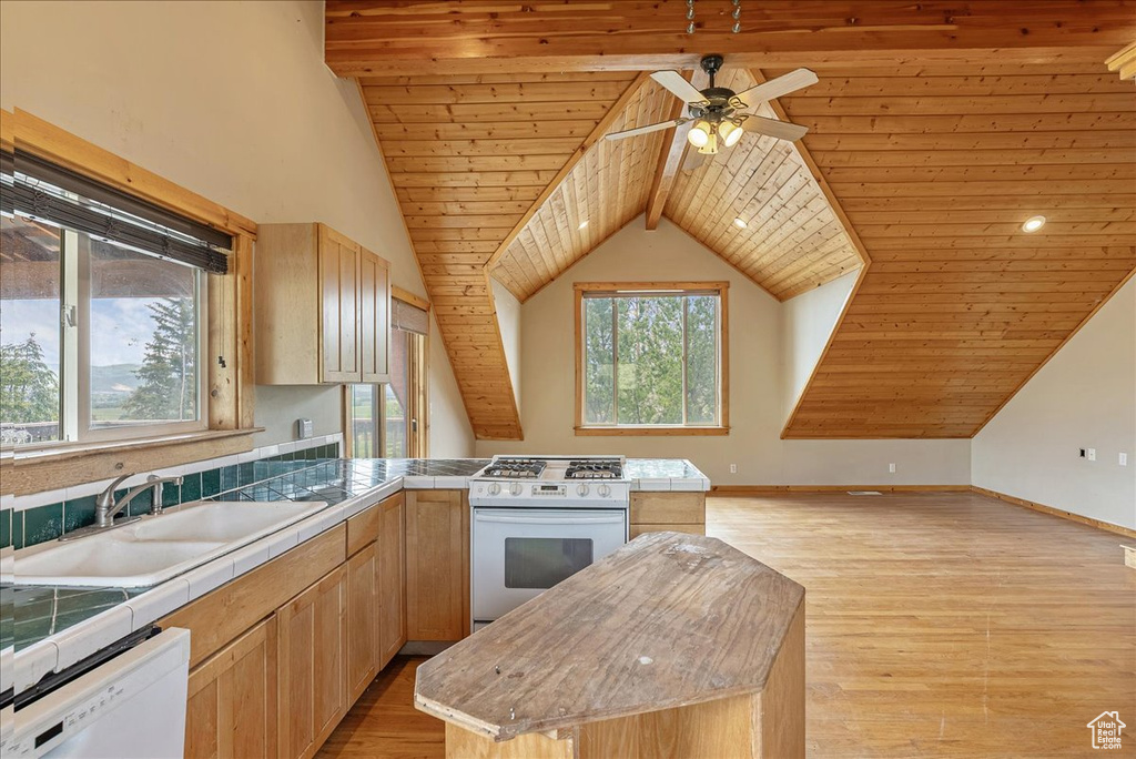 Kitchen featuring white appliances, light brown cabinets, wooden ceiling, tile countertops, and a peninsula
