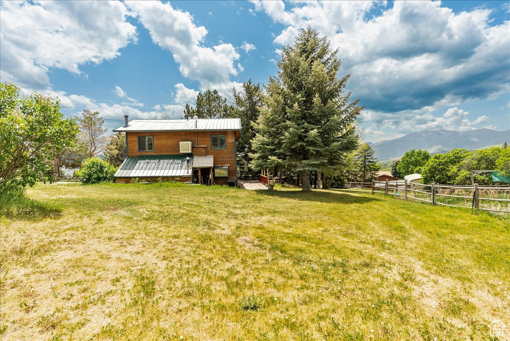 Back of property with a deck with mountain view and a metal roof
