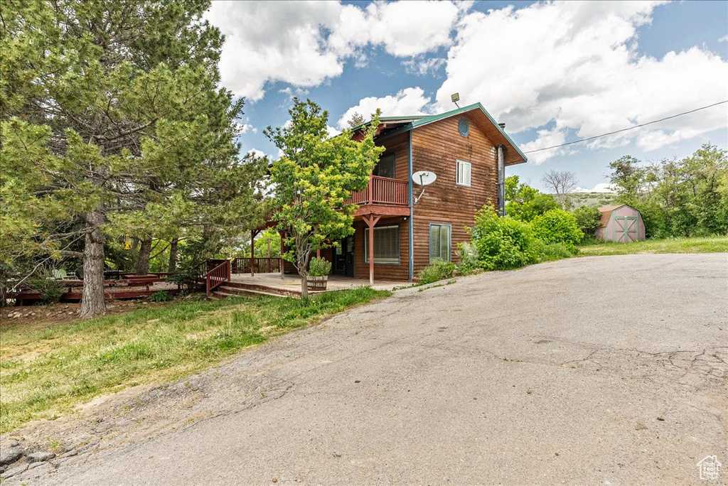 View of front of home featuring a storage shed and a wooden deck