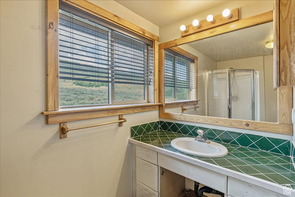 Full bath with a shower stall and vanity