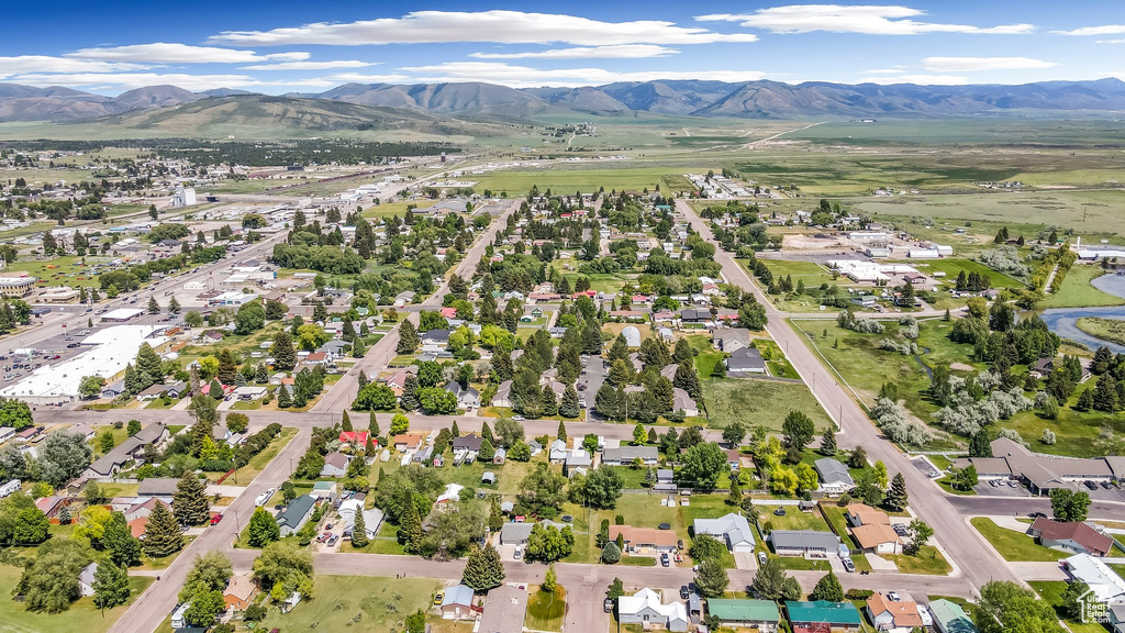 Aerial view of property and surrounding area with a mountainous background