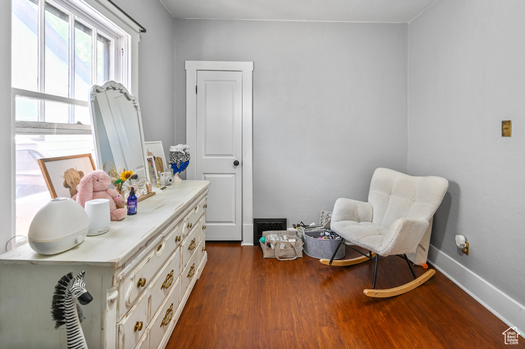 Living area featuring dark wood-style flooring and baseboards
