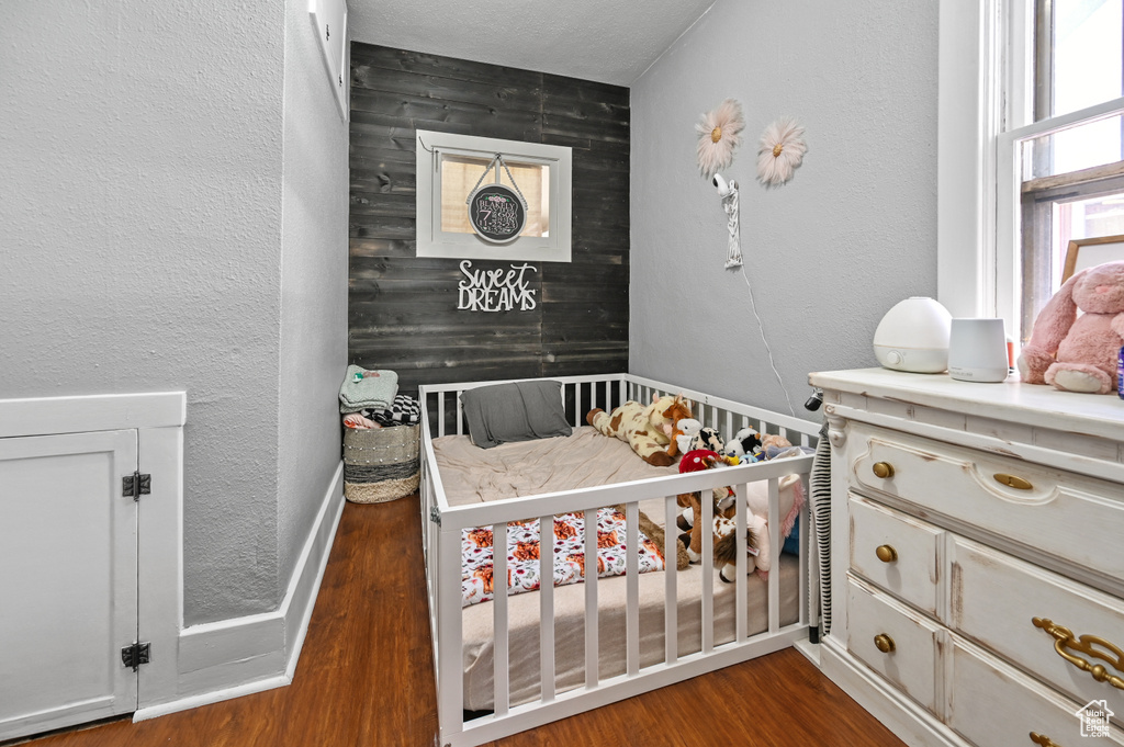 Bedroom featuring wood finished floors and a textured wall
