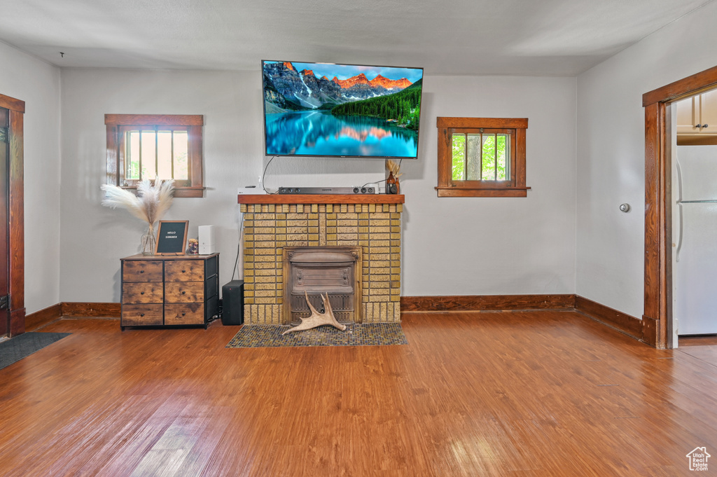 Living room with wood finished floors and a tiled fireplace