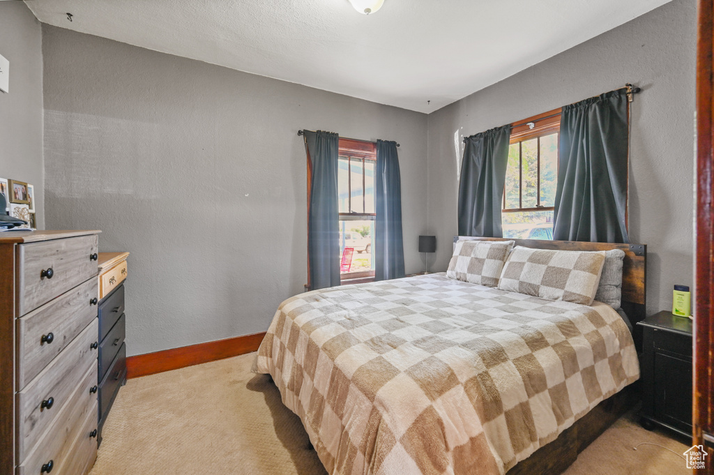 Bedroom with light colored carpet and baseboards