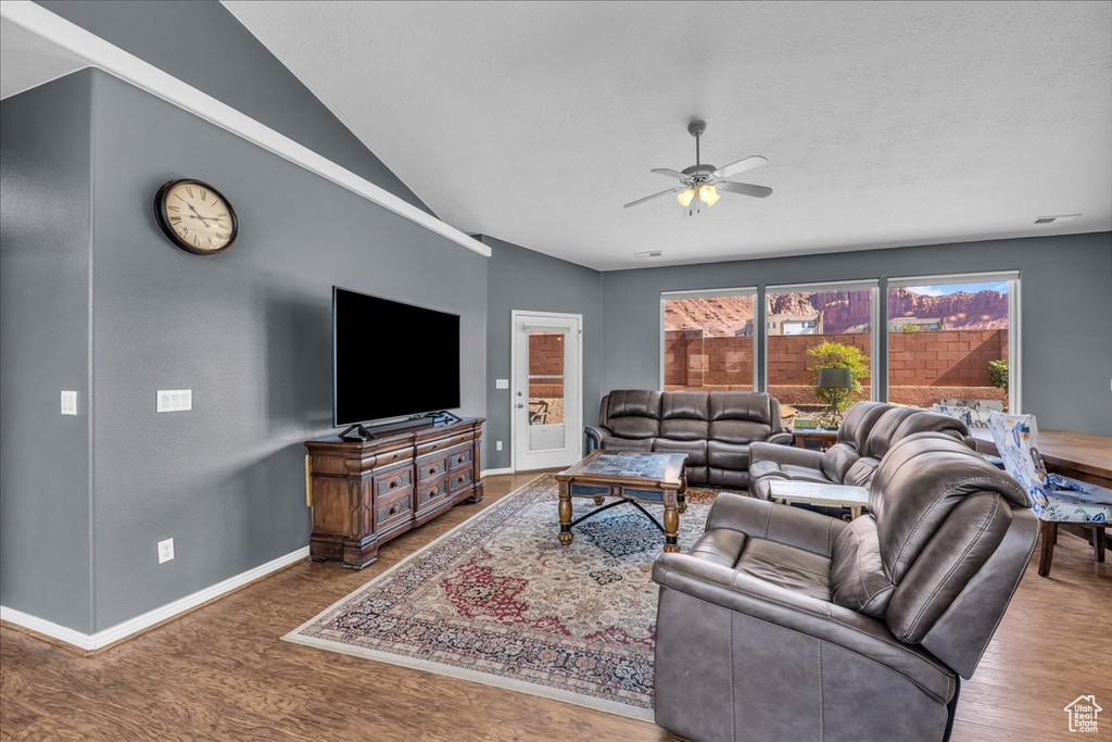 Living area featuring ceiling fan, wood finished floors, and lofted ceiling