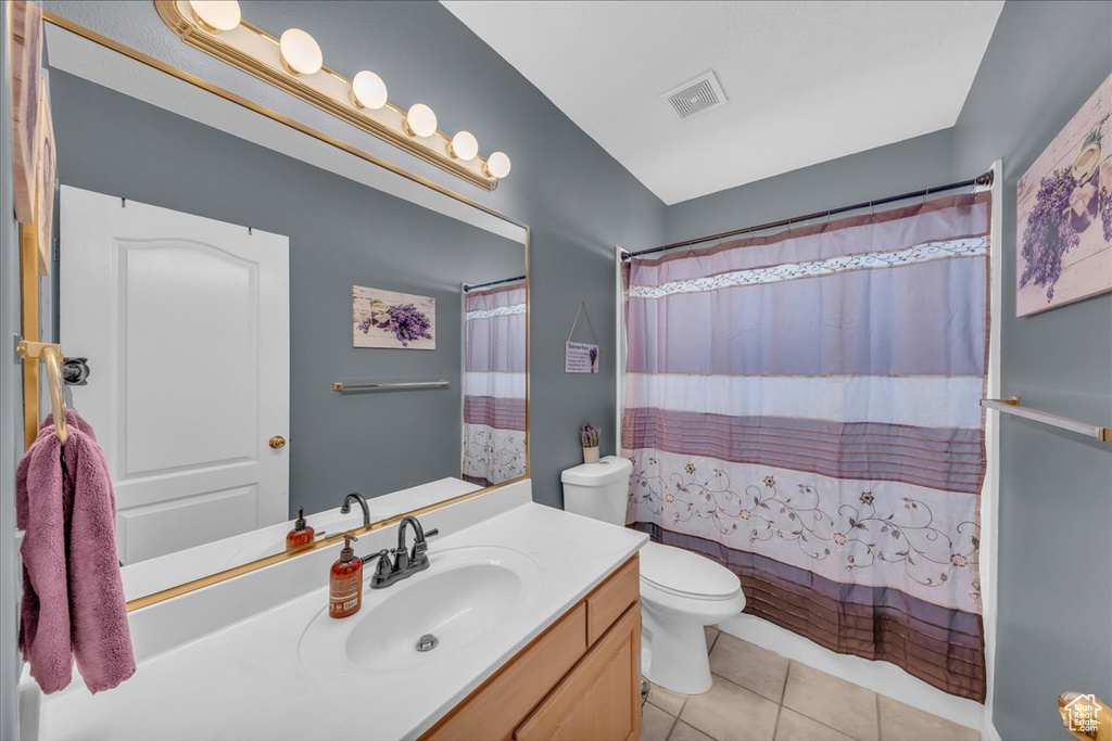 Bathroom featuring vanity, tile patterned floors, and shower / bath combo