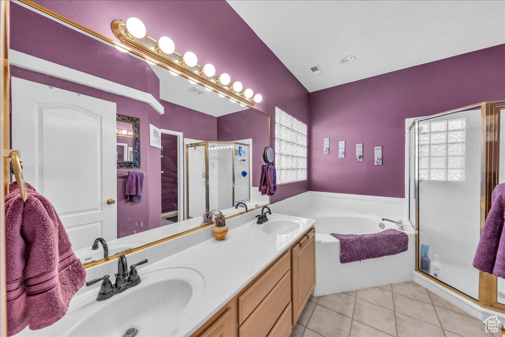 Bathroom featuring a shower stall, a garden tub, tile patterned flooring, and double vanity