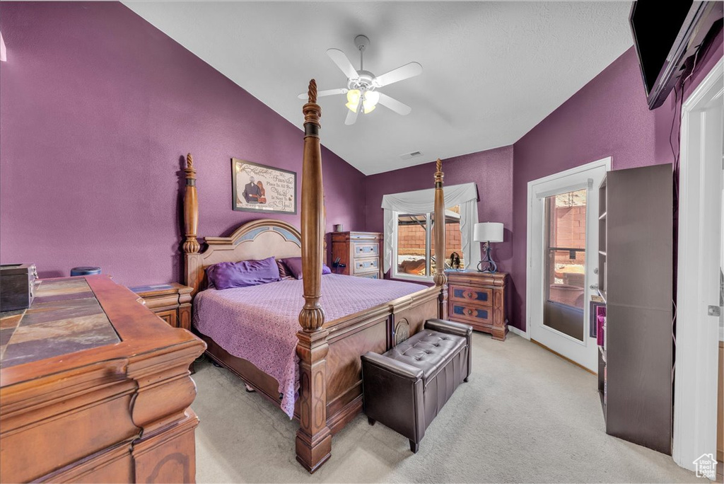 Bedroom featuring vaulted ceiling, light carpet, and a ceiling fan