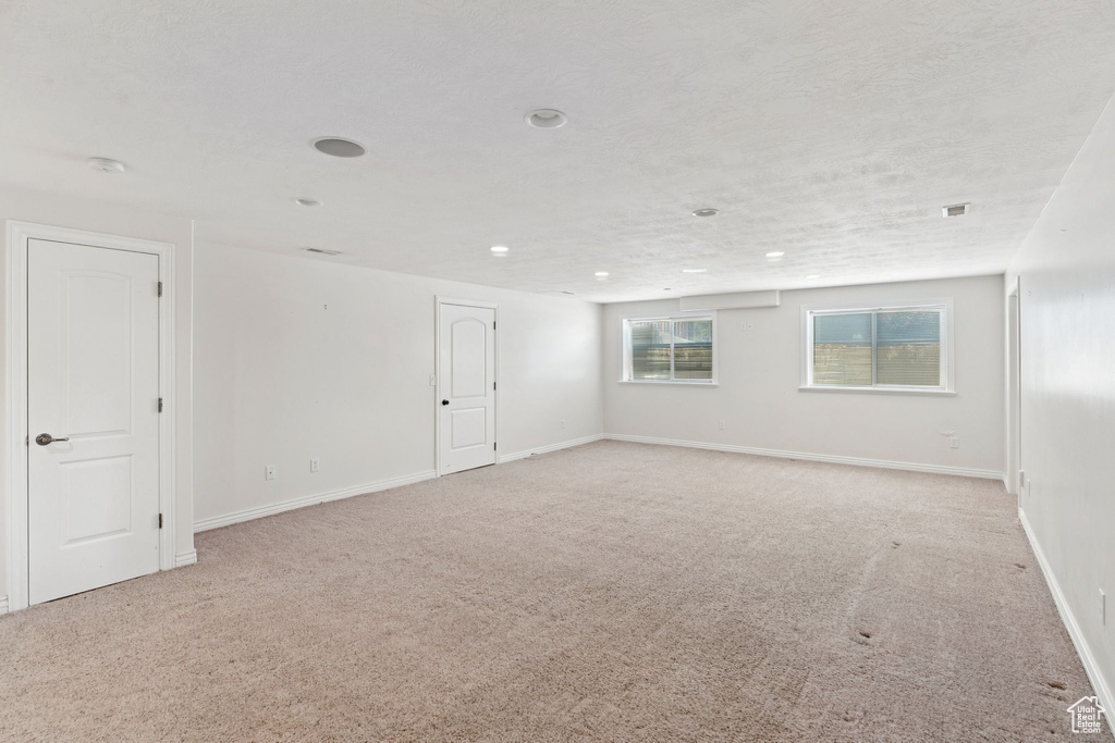 Empty room with light colored carpet, a smoke detector, and recessed lighting