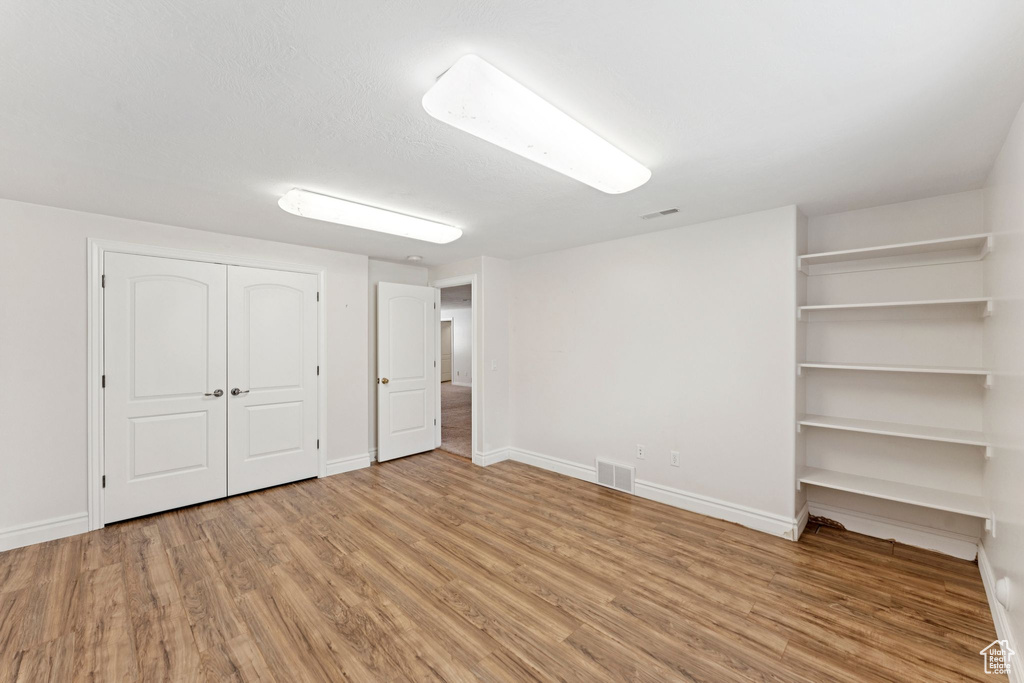 Unfurnished bedroom featuring wood finished floors and a closet