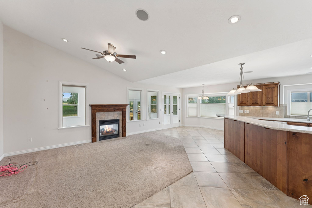 Kitchen with brown cabinets, light countertops, pendant lighting, a tile fireplace, and recessed lighting