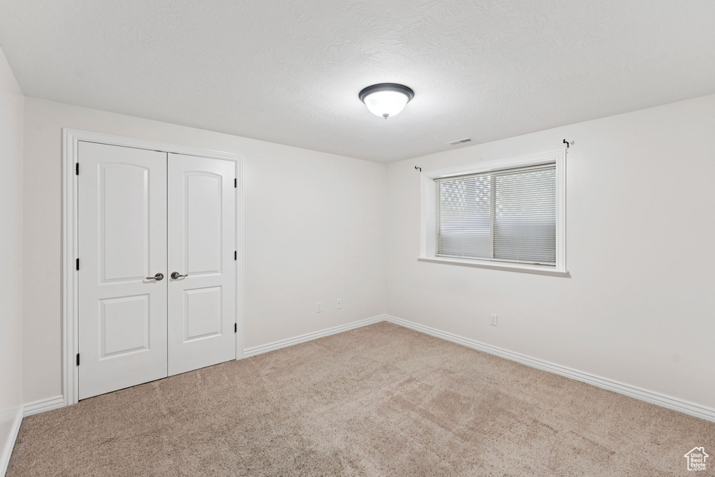 Unfurnished bedroom featuring carpet floors and a closet