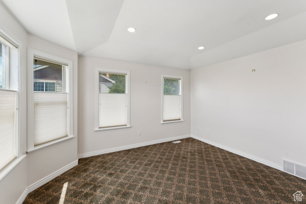 Carpeted empty room featuring recessed lighting and vaulted ceiling