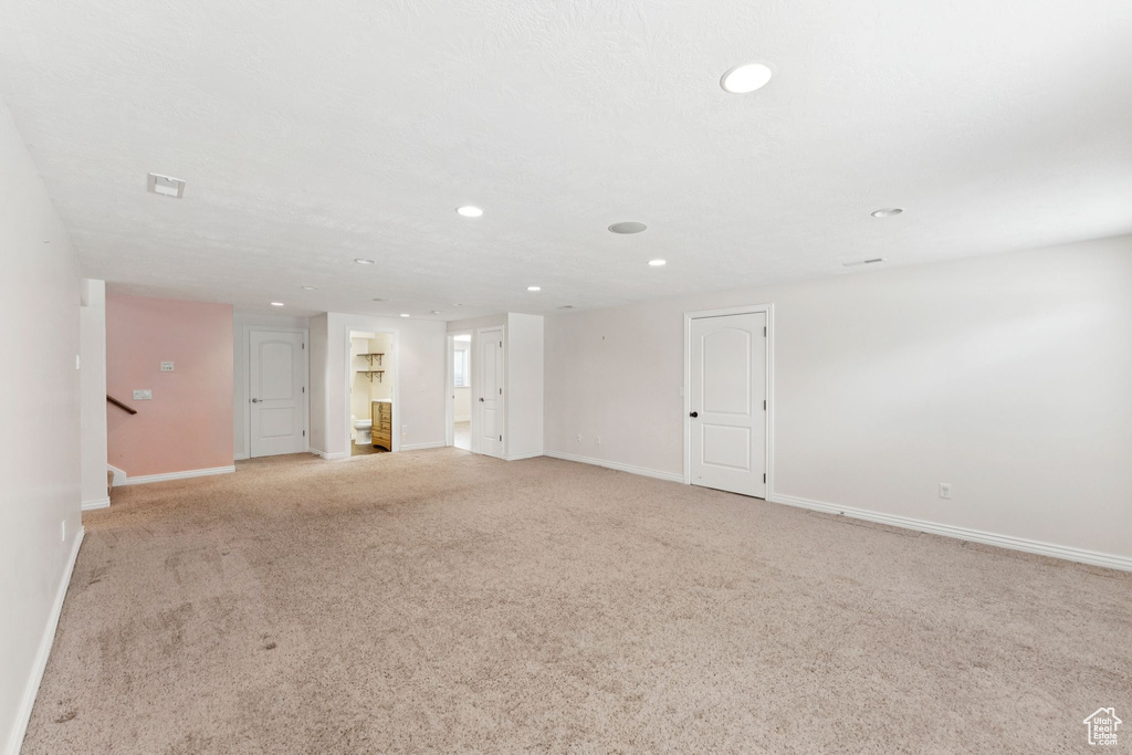 Unfurnished room featuring recessed lighting, light colored carpet, and stairway