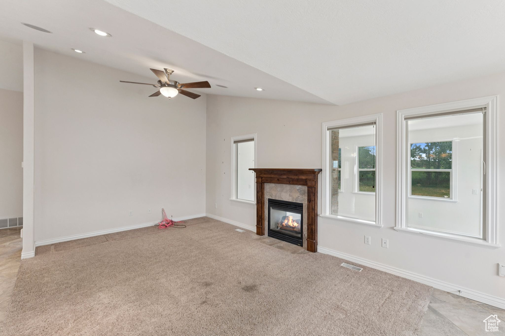 Unfurnished living room featuring lofted ceiling, light carpet, ceiling fan, a tile fireplace, and recessed lighting