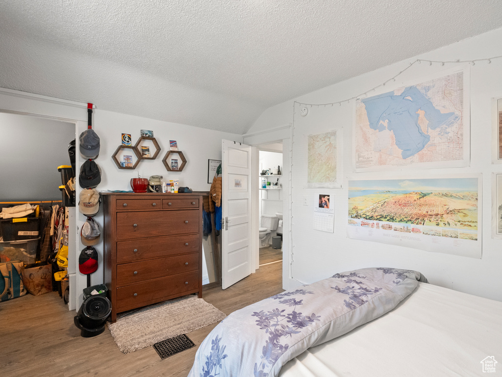 Bedroom with wood finished floors and a textured ceiling