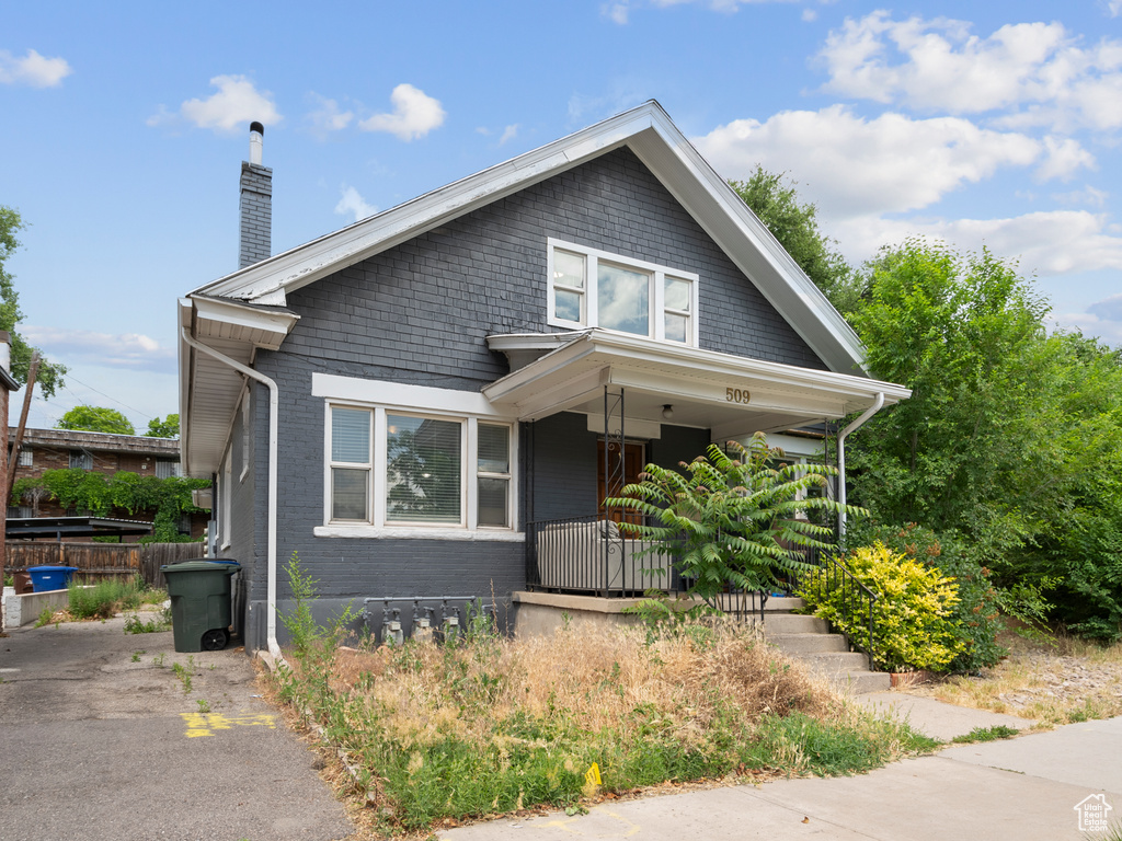 Bungalow-style house with a porch and a chimney