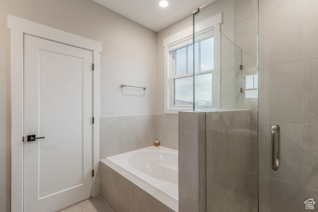 Full bathroom with a garden tub and a stall shower