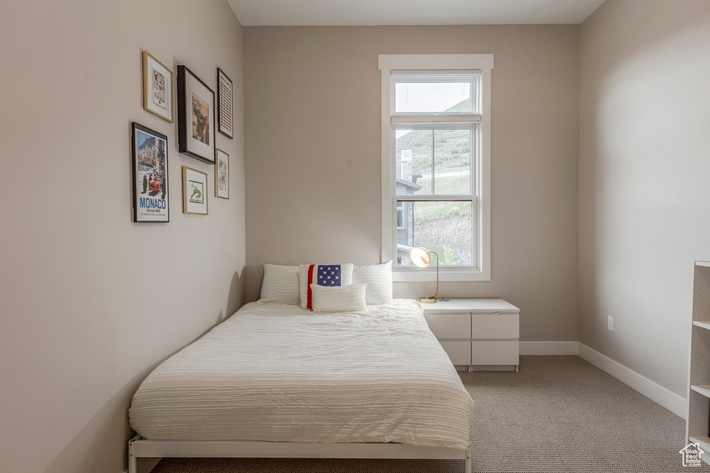Bedroom featuring light colored carpet and baseboards