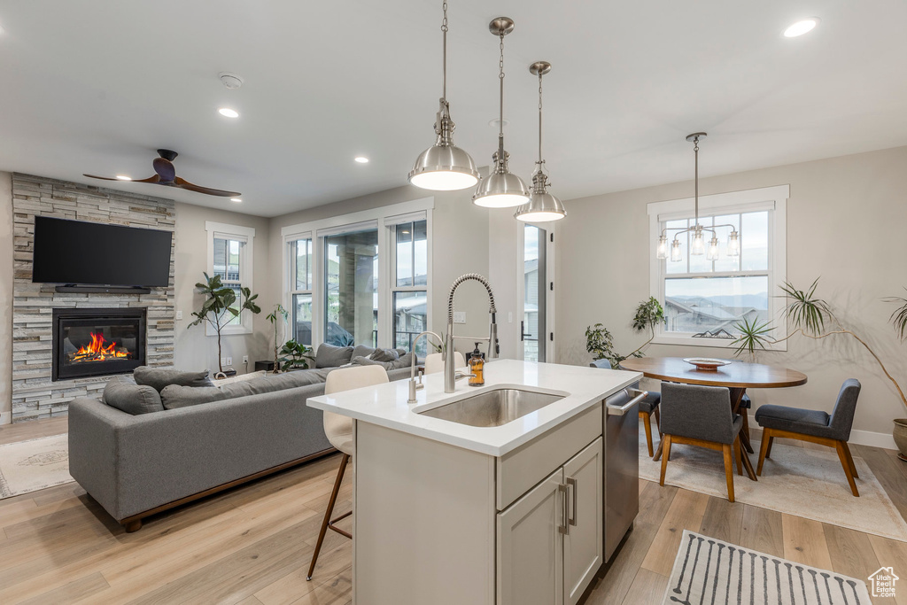 Kitchen with open floor plan, a ceiling fan, light wood finished floors, light countertops, and recessed lighting