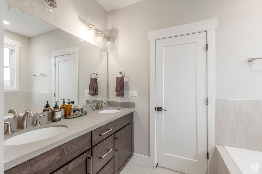 Bathroom featuring double vanity and tiled bath
