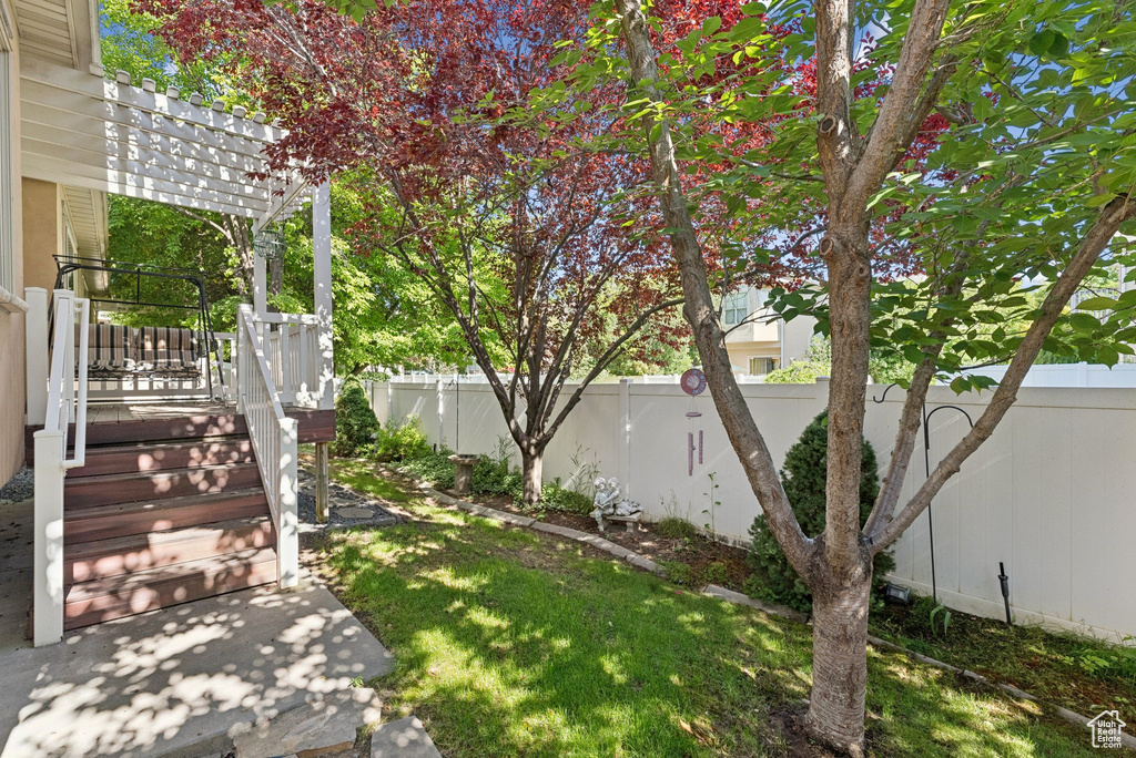 Fenced backyard featuring a pergola