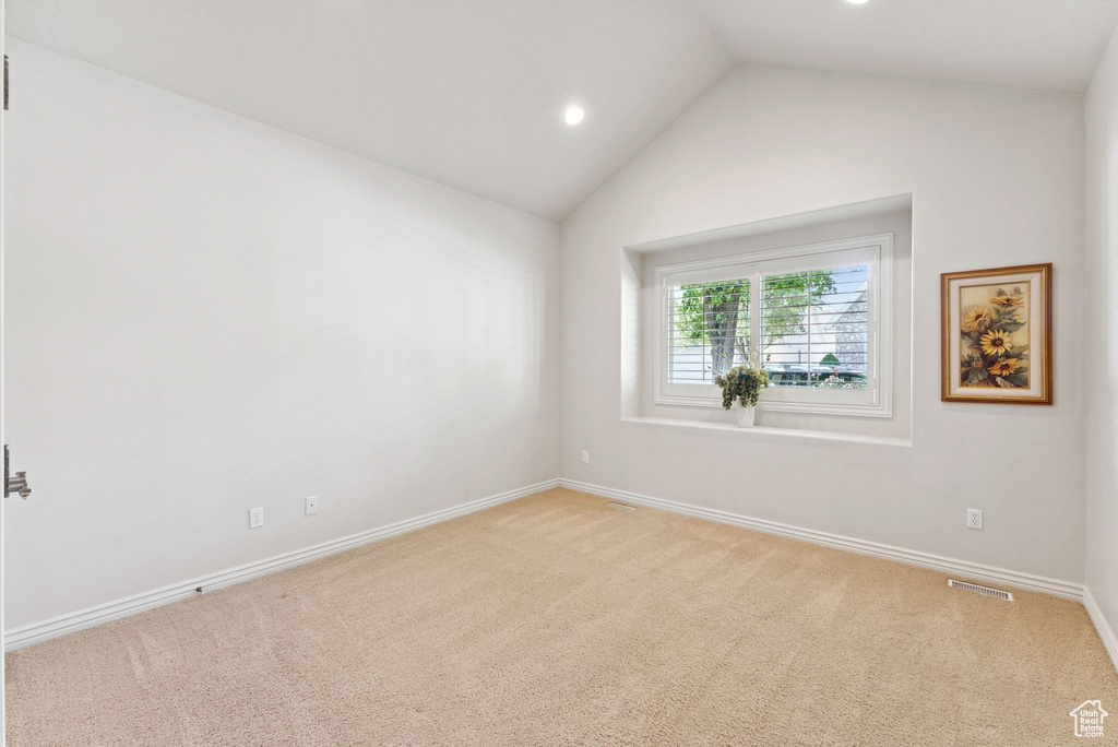 Empty room featuring carpet, vaulted ceiling, and recessed lighting