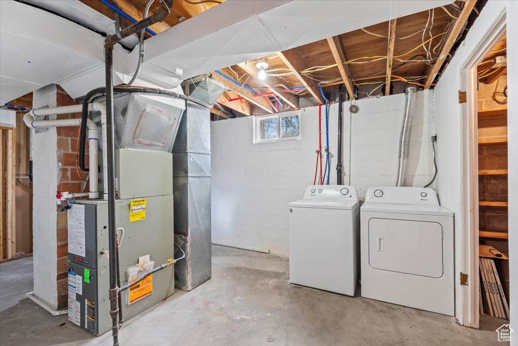 Below grade area with washing machine and clothes dryer and heating unit