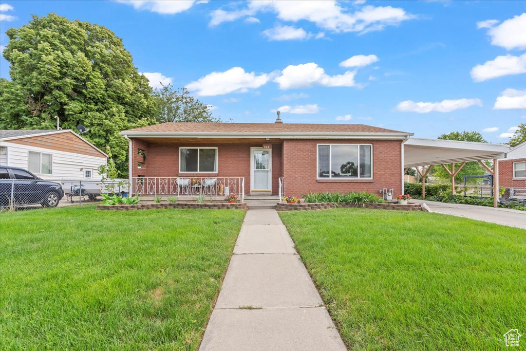 View of front of home with a porch, a carport, brick siding, and concrete driveway