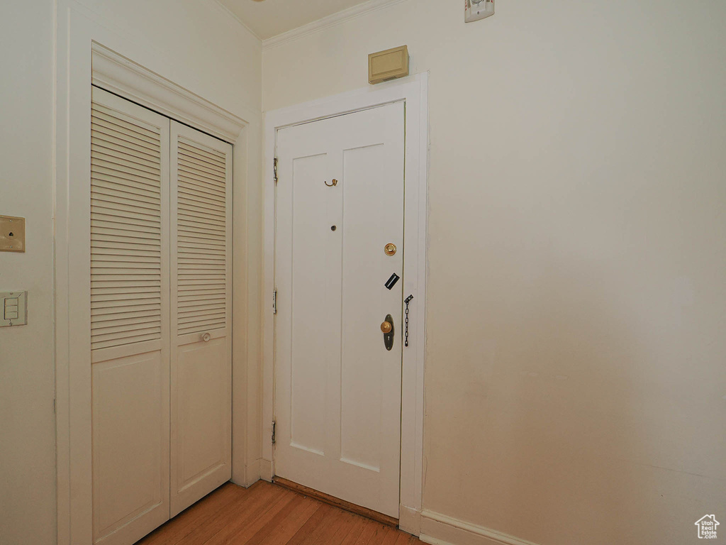 Entryway featuring light wood-type flooring and ornamental molding