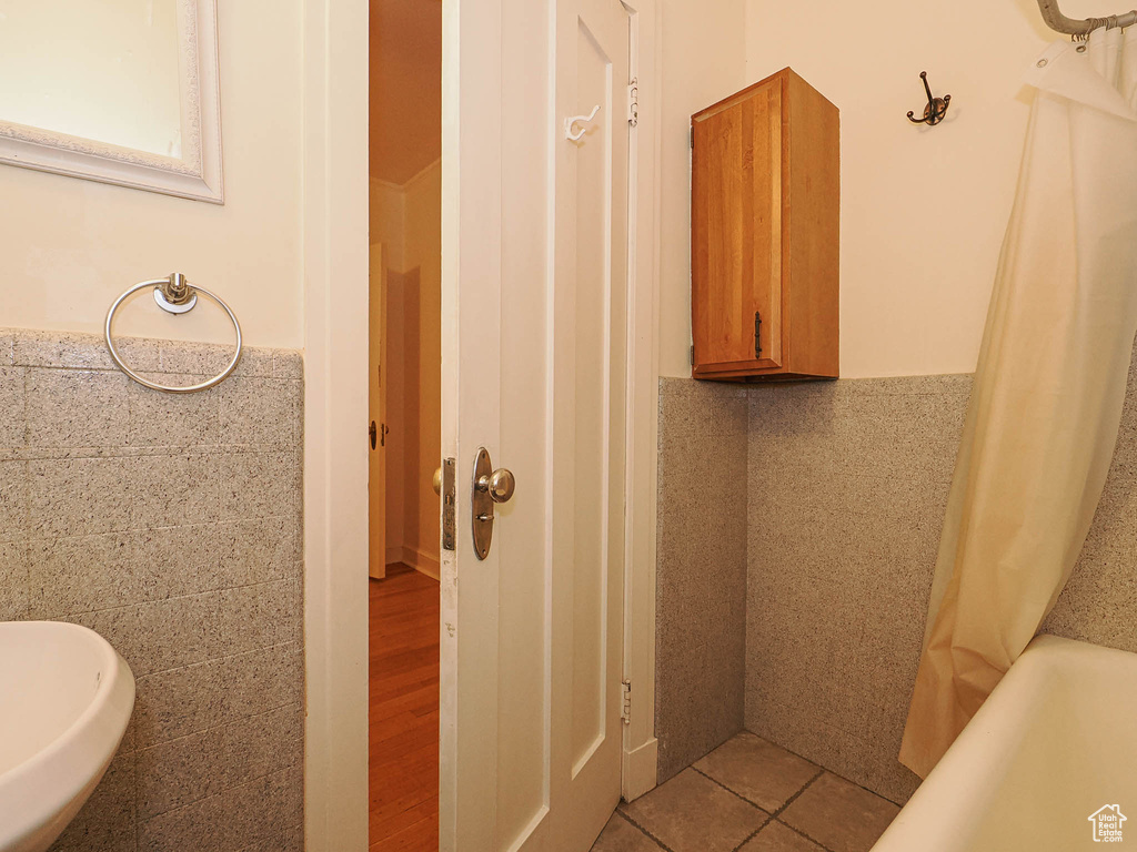 Full bath featuring tile walls
