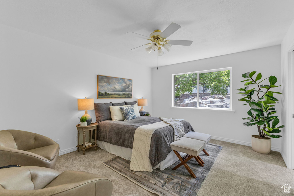 Carpeted bedroom with baseboards and a ceiling fan