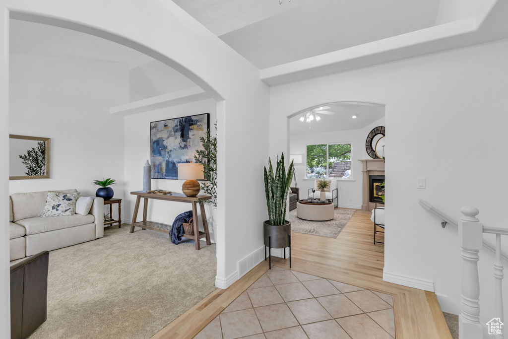 Hall featuring arched walkways and light wood-style floors
